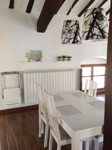 a white dining room with a white table and chairs at Apartamentos Turísticos Rincones del Vino in Ezcaray