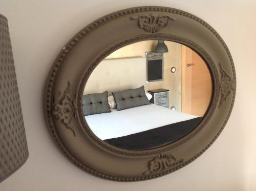 a mirror on a wall with a bed in a room at Apartamentos Turísticos Rincones del Vino in Ezcaray