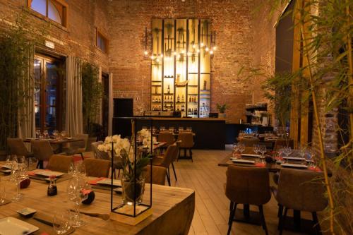 a restaurant with tables and chairs and a chandelier at Eburon Hotel in Tongeren