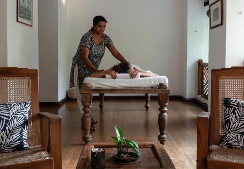 a woman laying on a bed in a room at Le Colonial 1506 - Exclusive Luxury Hideaway in Cochin