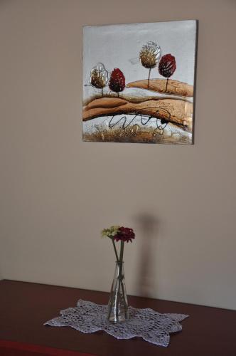 a vase with flowers on a table under a painting at Casa Rural Cancias in Fiscal