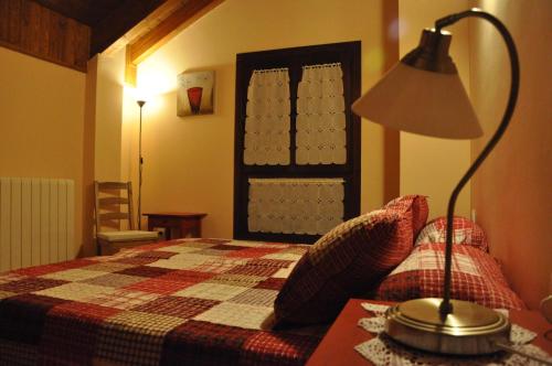 1 dormitorio con 1 cama y 1 lámpara en una mesa en Casa Rural Cancias, en Fiscal