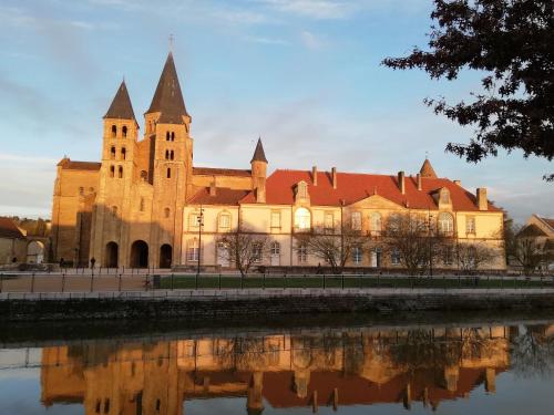 un vieux château avec une réflexion dans l'eau dans l'établissement Joli F1 au coeur de Paray, à Paray-le-Monial