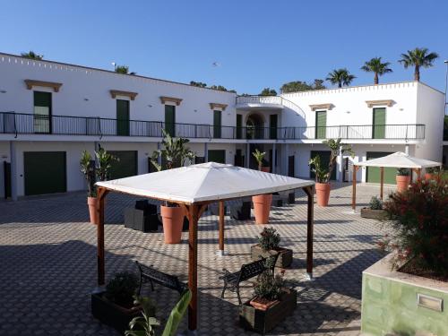 - une vue sur la cour d'un bâtiment avec tente dans l'établissement Residence Cala Verde, à Marina di Mancaversa