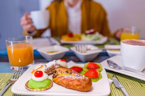 a table with a plate of food on a table at Le Maestranze Deluxe Rooms in Sciacca