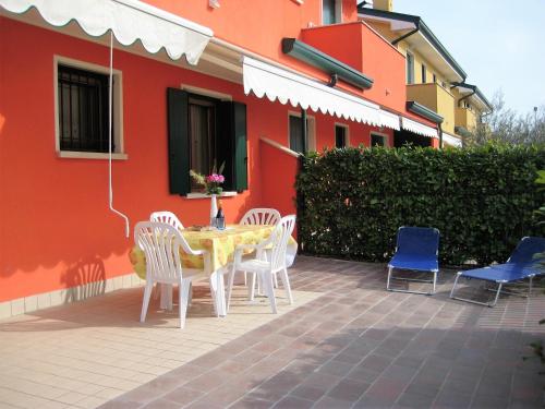 a patio with a table and chairs next to a building at RESORT VILLAGE AQUA MARINA FAMILY - Daily Rooms Tidying - CocktailsBar- Pet Friendly - with Hypermarket - Delivery Restaurant-Pizzeria - Room Breakfast with supplement - Ultra Fast Wi-Fi - Play Area for children - Olympic Swimming Pool - Parking in Caorle
