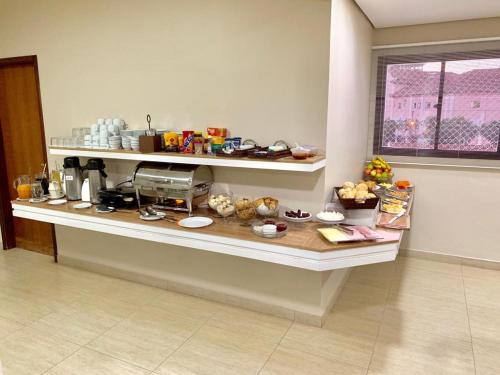 a kitchen with a counter with food on it at Hotel Flat Alameda in Araçatuba