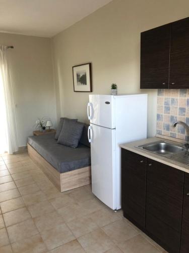 a small kitchen with a white refrigerator and a sink at Red Coral Apartments in Vatopedi