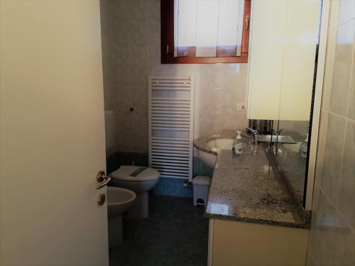 a bathroom with a toilet and a sink and a toilet istg at RESORT VILLAGE AQUA MARINA FAMILY - Daily Rooms Tidying - CocktailsBar- Pet Friendly - with Hypermarket - Delivery Restaurant-Pizzeria - Room Breakfast with supplement - Ultra Fast Wi-Fi - Play Area for children - Olympic Swimming Pool - Parking in Caorle