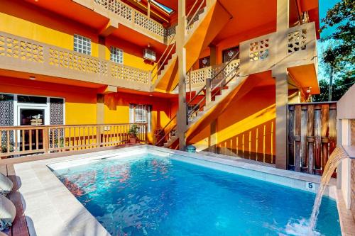 a swimming pool in front of a building at Hummingbird Home Suites in San Pedro