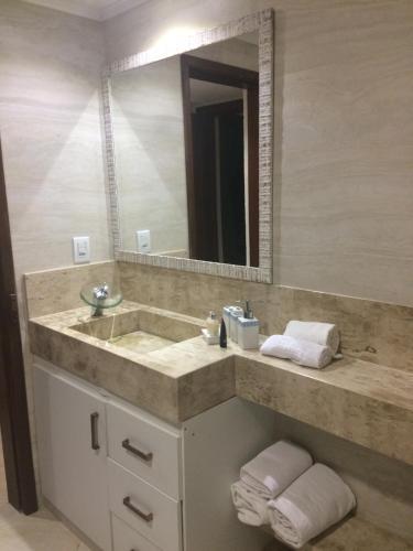 a bathroom with a sink and a mirror at Casa Luxo Frente ao Mar in Arraial d'Ajuda