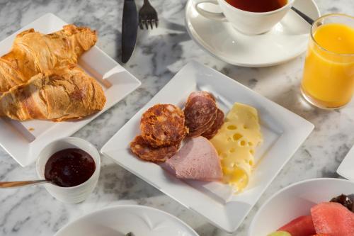 a table topped with plates of breakfast foods and orange juice at Bartley Lodge Hotel in Lyndhurst