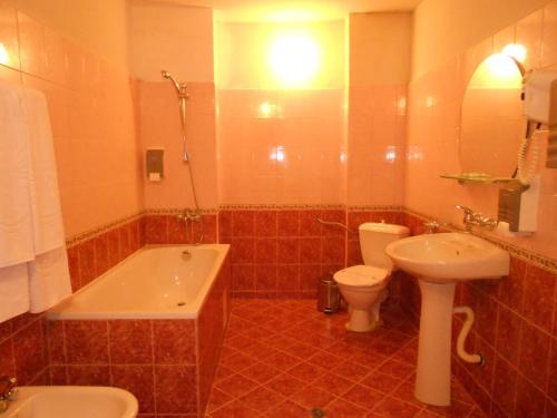 La salle de bains est pourvue d'une baignoire, de toilettes et d'un lavabo. dans l'établissement Хотел "Калина", à Borovets