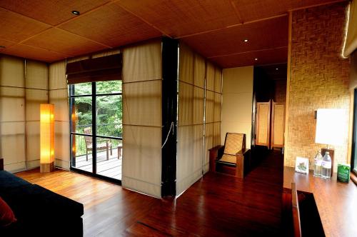 a living room with wooden floors and a glass door at The Rainforest Ecolodge - Sinharaja in Deniyaya