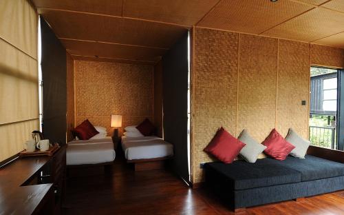 a room with two beds and a couch in it at The Rainforest Ecolodge - Sinharaja with Shuttle Service from Car Park in Deniyaya