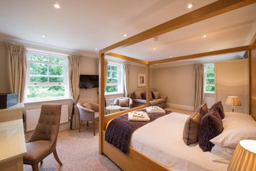 a bedroom with a large bed and a desk at Bartley Lodge Hotel in Lyndhurst