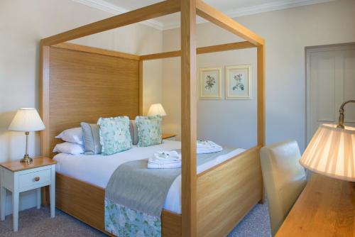 a bed room with a bed and a desk at Bartley Lodge Hotel in Lyndhurst