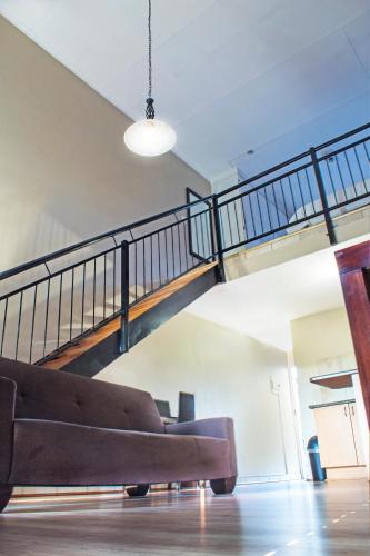 a living room with a couch and a staircase at Hotel @ Tzaneen in Tzaneen