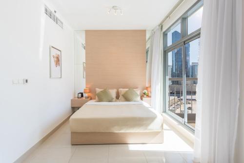 a bedroom with a bed and a large window at bnbmehomes - Elegant & Stylish Studio in Downtown - 502 in Dubai