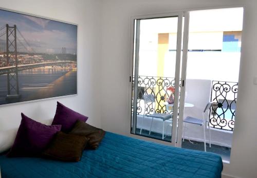 un divano blu in una stanza con una grande finestra di Arts, Cultural & Design District with a Sunny View a Lisbona