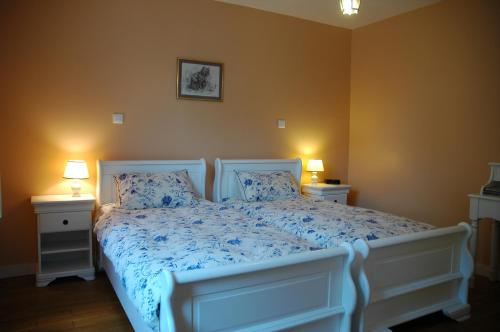 アラドンにあるChambre D'Hôtes Mont D'Hermineのベッドルーム1室(白いベッド1台、青いシーツ、ランプ2つ付)