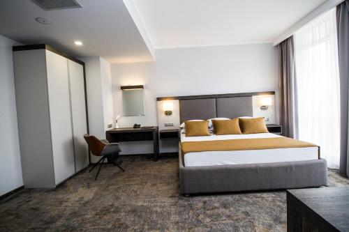 a hotel room with a bed and a desk at Best Western PLUS Premium Inn in Sunny Beach