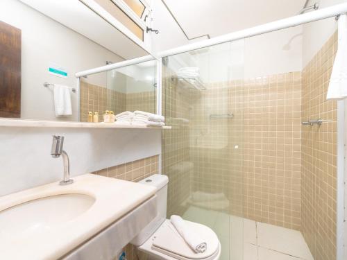 a bathroom with a shower and a toilet and a sink at Hotel Costa Norte Massaguaçu in Caraguatatuba