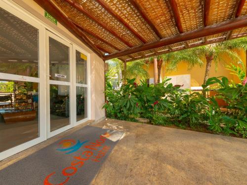 a house with a welcome mat on the porch at Hotel Costa Norte Massaguaçu in Caraguatatuba