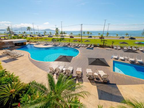 an aerial view of a resort with a pool and chairs at Hotel Costa Norte Massaguaçu in Caraguatatuba