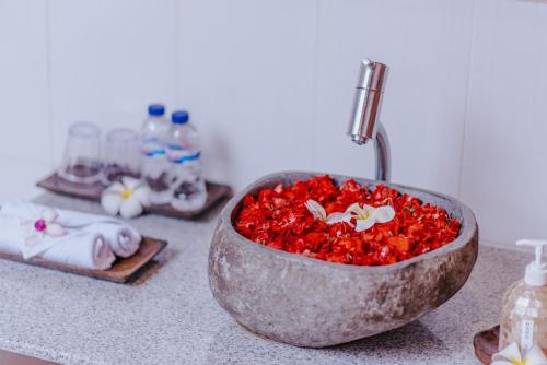 a bowl filled with red beads sitting on a counter at Lembongan Small Heaven Bungalow in Nusa Lembongan