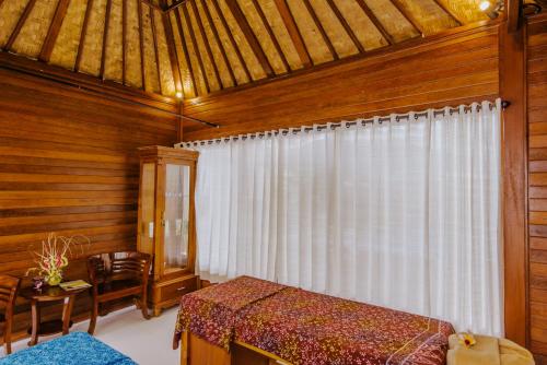 a bedroom with a bed and a window in a room at Lembongan Small Heaven Bungalow in Nusa Lembongan