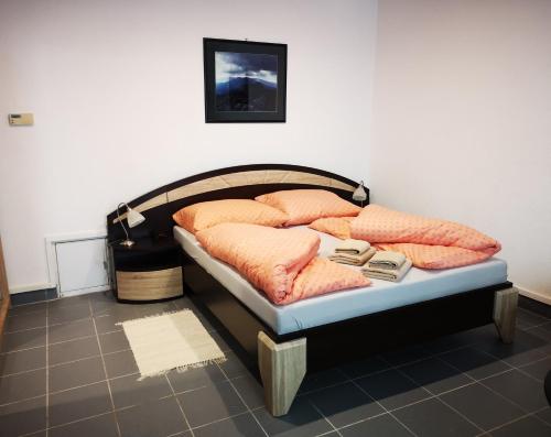 una cama con almohadas en una habitación en Penzion Rotunda, en Liptovský Mikuláš
