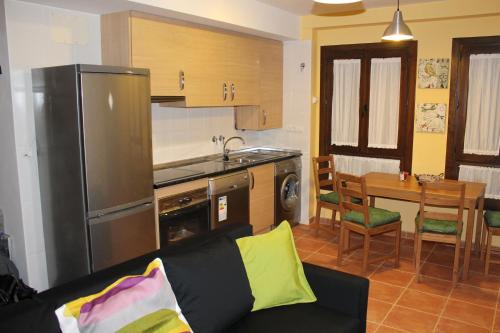 Casa Rural Cancias في فيزكال: مطبخ مع أريكة وطاولة في الغرفة