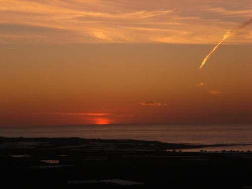 a sunset over the ocean with the sun setting at The Stonemade Houses in Falasarna