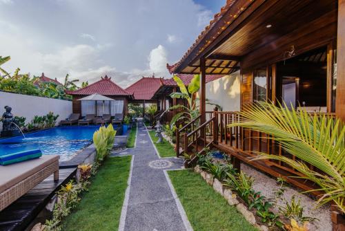 a house with a swimming pool next to a house at Lembongan Small Heaven Bungalow in Nusa Lembongan