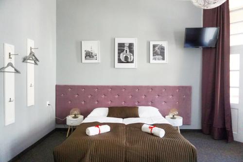 a bedroom with a large bed with a purple headboard at Expolis Residence - City Center - 24h POZNAŃ GŁÓWNY #betterthanyourEX in Poznań