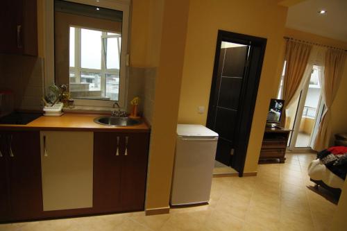 a kitchen with a sink and a window and a door at Kopernikus Apartments in Ulcinj