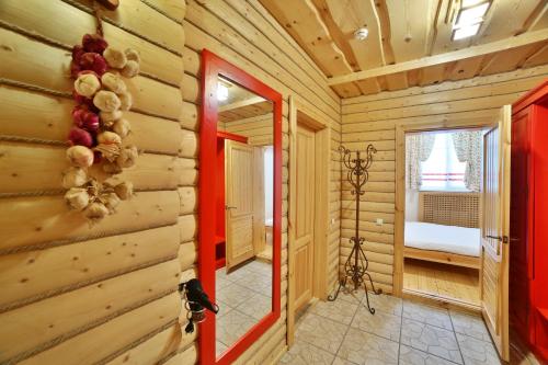 a log cabin hallway with a red door and a mirror at Voyage Hotel in Penza