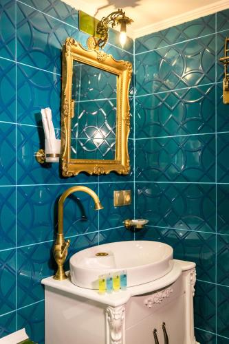 a bathroom with blue tiled walls and a mirror at Tiflis Inn Boutique Hotel in Tbilisi City
