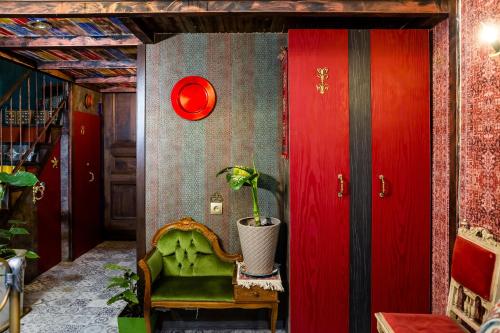 a room with a green chair and a red wall at Tiflis Inn Boutique Hotel in Tbilisi City