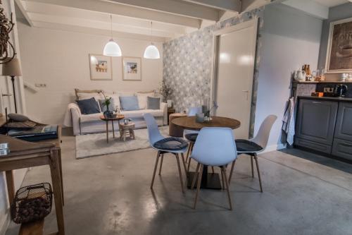 ein Wohnzimmer mit einem Tisch, Stühlen und einem Sofa in der Unterkunft Blauwe Lucht in Deurne
