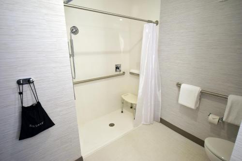 a bathroom with a shower with a toilet and a sink at Legacy Hotel at IMG Academy in Bradenton