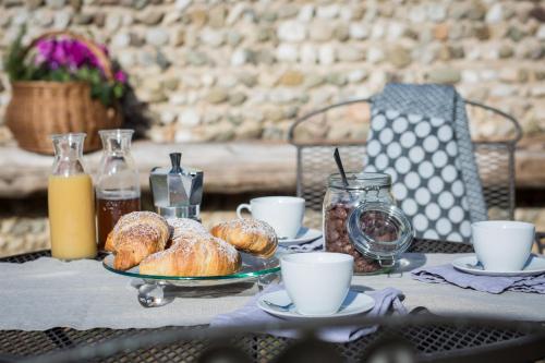 a table with a plate of pastries and cups of coffee at EDERA dei Guatto in Bertiolo