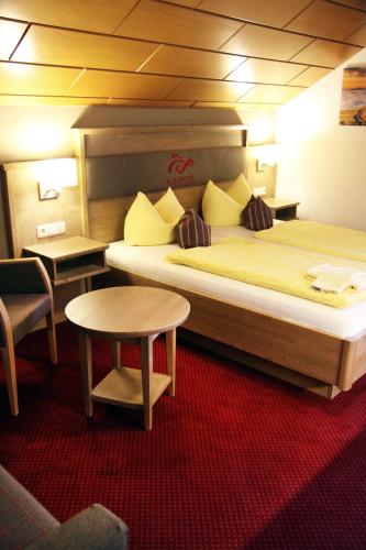 a hotel room with a large bed and a table at Waldhotel Seebachschleife in Bayerisch Eisenstein