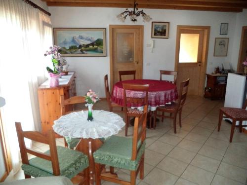 une salle à manger avec une table et des chaises rouges dans l'établissement B&B Dolomiti, à Calalzo di Cadore