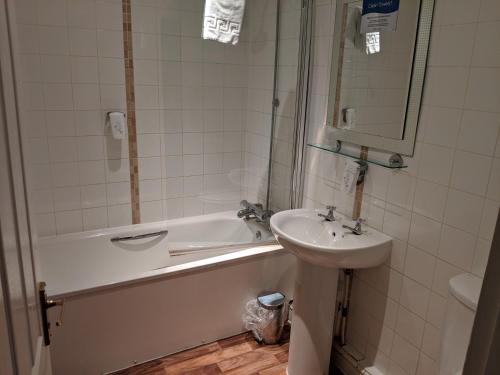 y baño con lavamanos, bañera y lavamanos. en White Hart, Andover by Marston's Inns en Andover