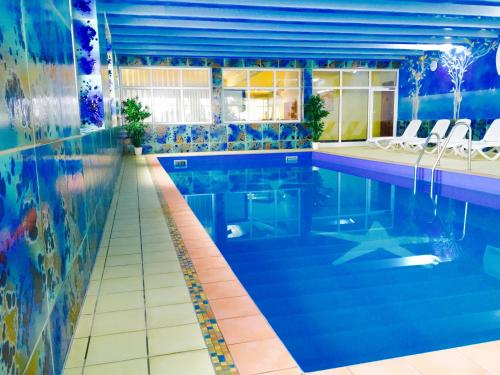 una gran piscina con azulejos azules y una piscina en Waldhotel Seebachschleife en Bayerisch Eisenstein