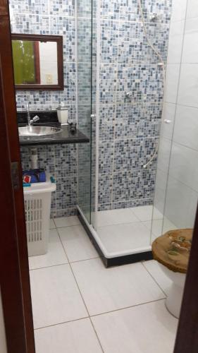 a bathroom with a shower and a sink at Paraiso de lazer e festa. in Maricá