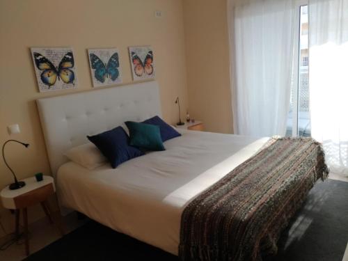 een slaapkamer met een groot bed met vlinders aan de muur bij Sunny apartamento in Portimão