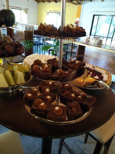 a table filled with different types of cakes and pastries at Complejo Cantonavi in Mina Clavero